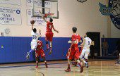 Burroughs' Lawrence White, #3, goes high above the basket to block the shot of Burbank's Peter Wongsasitorn (Photo by Ross A. Benson)