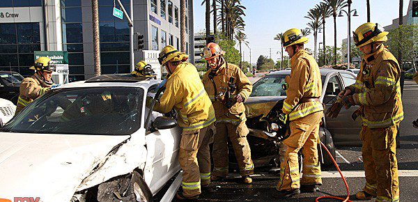 Burbank Firefighters prepare to use hydraulic cutting tools to get the drivers door open so Burbank Paramedics can treat the victim. (Photo by Ross A. Benson)