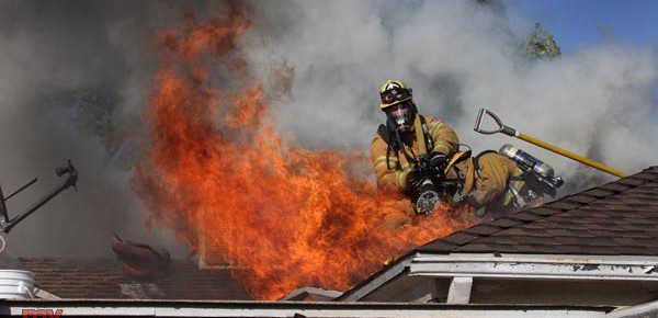 Burbank Firefighters work at ventilating this attic fire and putting water on the flames at a residence in the 700 Blk of Kenwood Street Thursday afternoon. (Photo by Ross A. Benson)