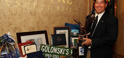Dave wears a Fire Fighters helmet that was given to him with his name inscribed on it from The Burbank Fire Department as he holds a Golden Eagle that the Police Chief presented to him. (Photo by Ross A. Benson)