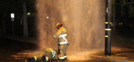 Burbank Firefighters attempt to shut the valve that controls this sheared fire hydrant at Edison & Valley Streets. (Photo by Ross. Benson)