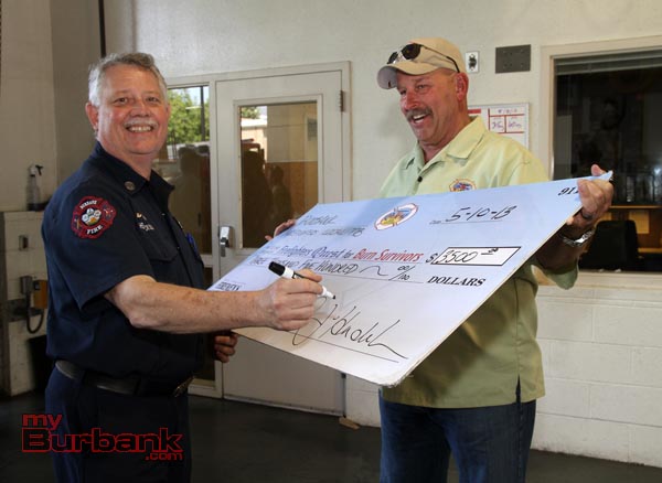 Burbank Firefighters Local 778 Director Peter Henderson sign a BIG check in the amount of $3500.00, as Jeff Howe from Quest assists.(Photo by Ross A. Benson)