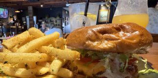 Magnolia Corner Opens With Revamped Space, Solid Bar Menu Magnolia Corner's Classic Beef Cheeseburger is topped with cheddar cheese, cocktail sauce, tzatziki, grilled onions, lettuce and tomato and accompanied by fries seasoned with parsley, salt and pepper.