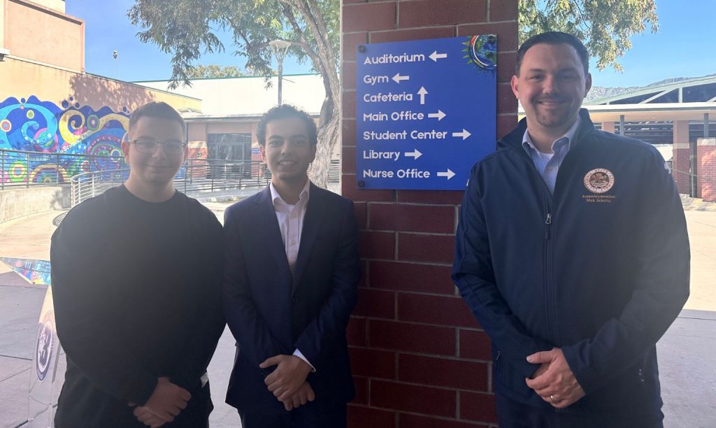 Assemblyman Nick Schultz stands with students Vladimir Hovhannisyan and David Djinbachian next to a new campus wayfinding sign