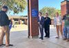 Burbank High Students Lead Wayfinding Project to Make Campus Safer and More Welcoming Two students and three school officials smile as they use large scissors to cut a ribbon in front of a new campus wayfinding sign at Burbank High School.