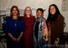 Zonta Club of Burbank Celebrates 90 Years of Empowering Women Four attendees pose together at the Zonta Club of Burbank Area's 90th Anniversary celebration. The group stands in front of event signage recognizing the anniversary and honoring Gloria Salas. One attendee wears a royal blue outfit, another a red dress, a third a colorful patterned shawl, and a fourth a brown blouse with light-colored pants. The indoor event space includes displays and presentation materials related to the celebration.