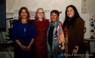 Zonta Club of Burbank Celebrates 90 Years of Empowering Women Four attendees pose together at the Zonta Club of Burbank Area's 90th Anniversary celebration. The group stands in front of event signage recognizing the anniversary and honoring Gloria Salas. One attendee wears a royal blue outfit, another a red dress, a third a colorful patterned shawl, and a fourth a brown blouse with light-colored pants. The indoor event space includes displays and presentation materials related to the celebration.